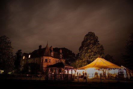 Shillingstone House lit at night with a marquee on the lower lawn