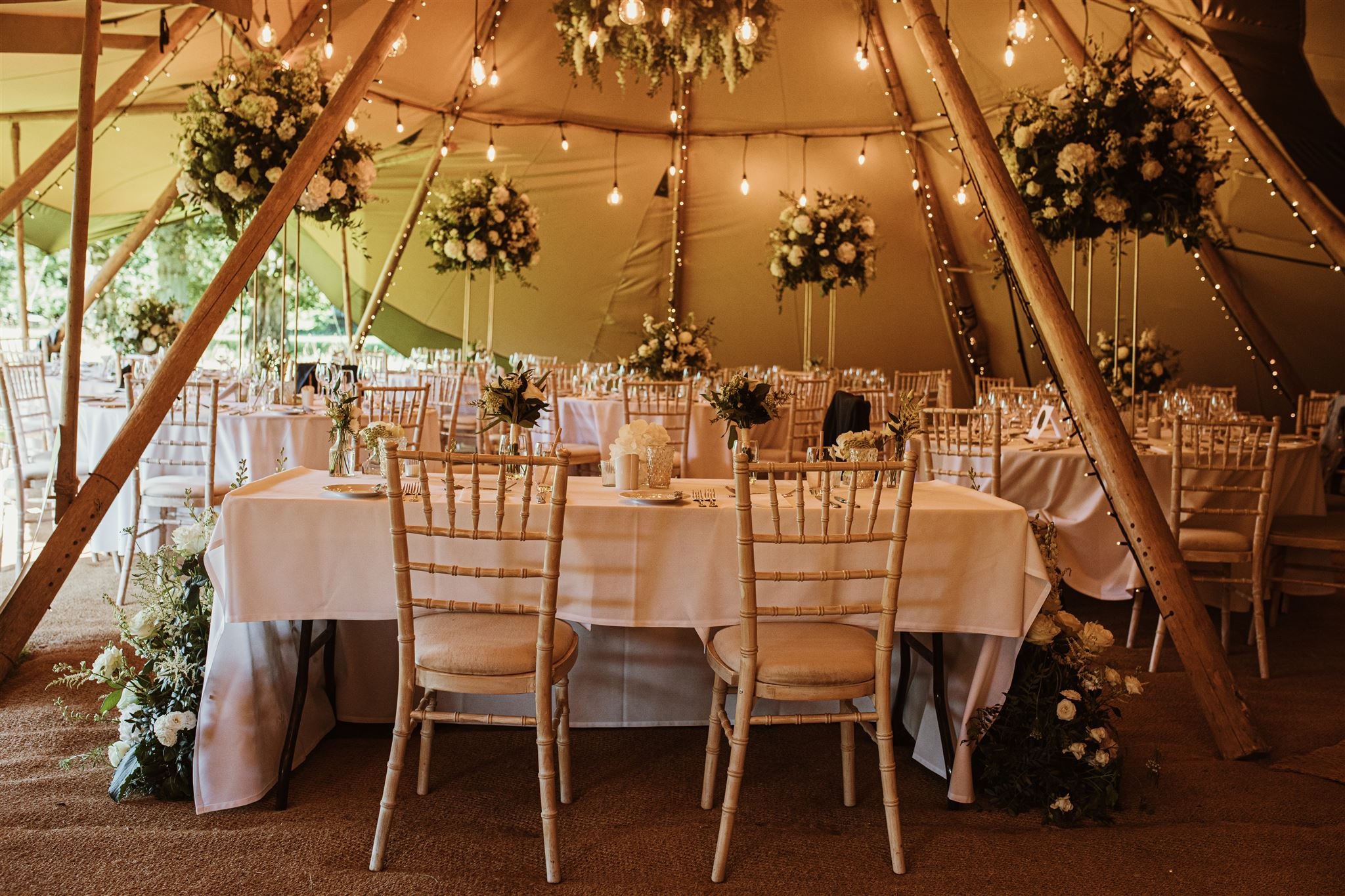 White wedding floral decorations in tipi