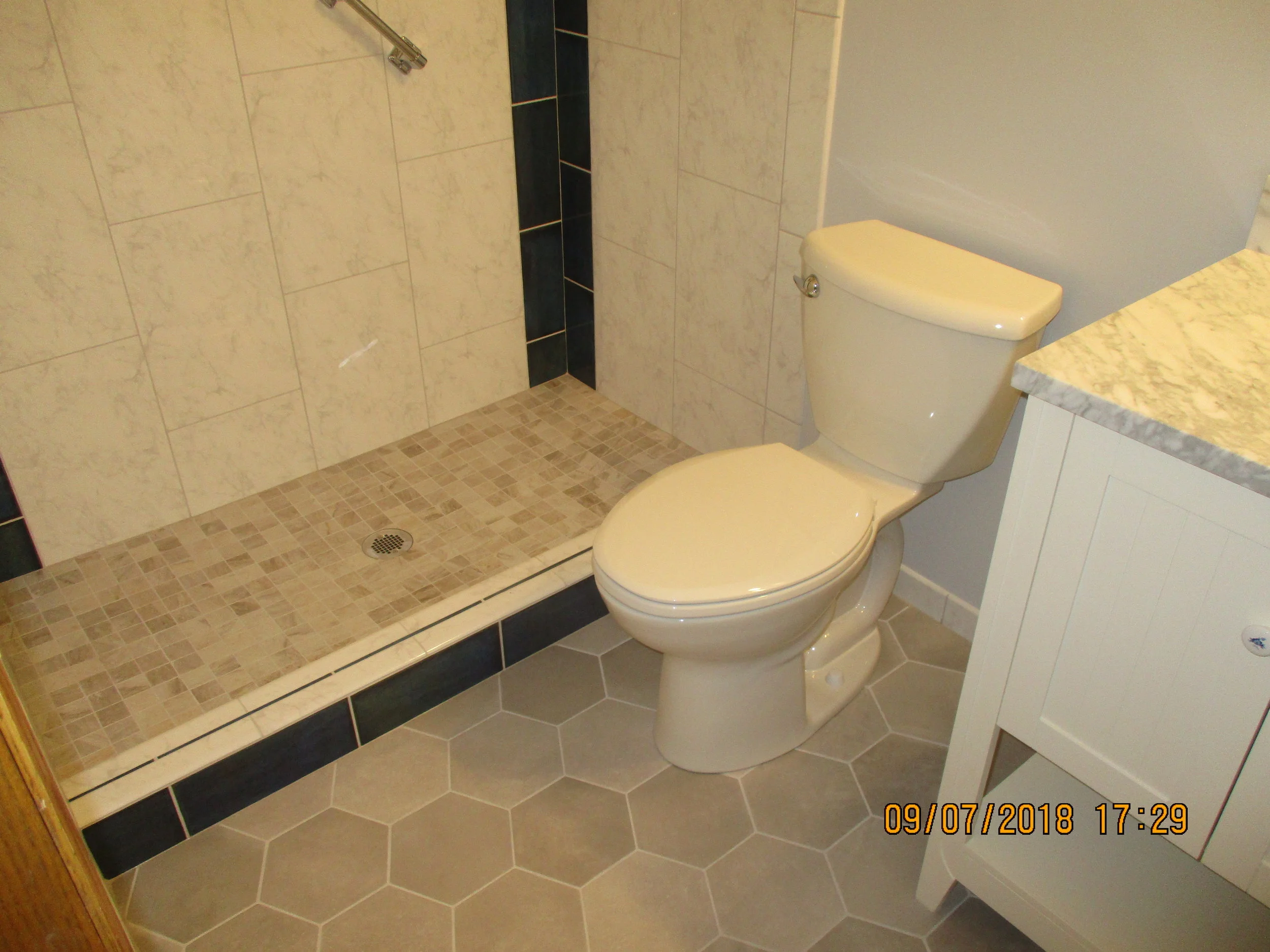 New custom shower pan and wall tile, big hexagon floor tile, toilet and vanity