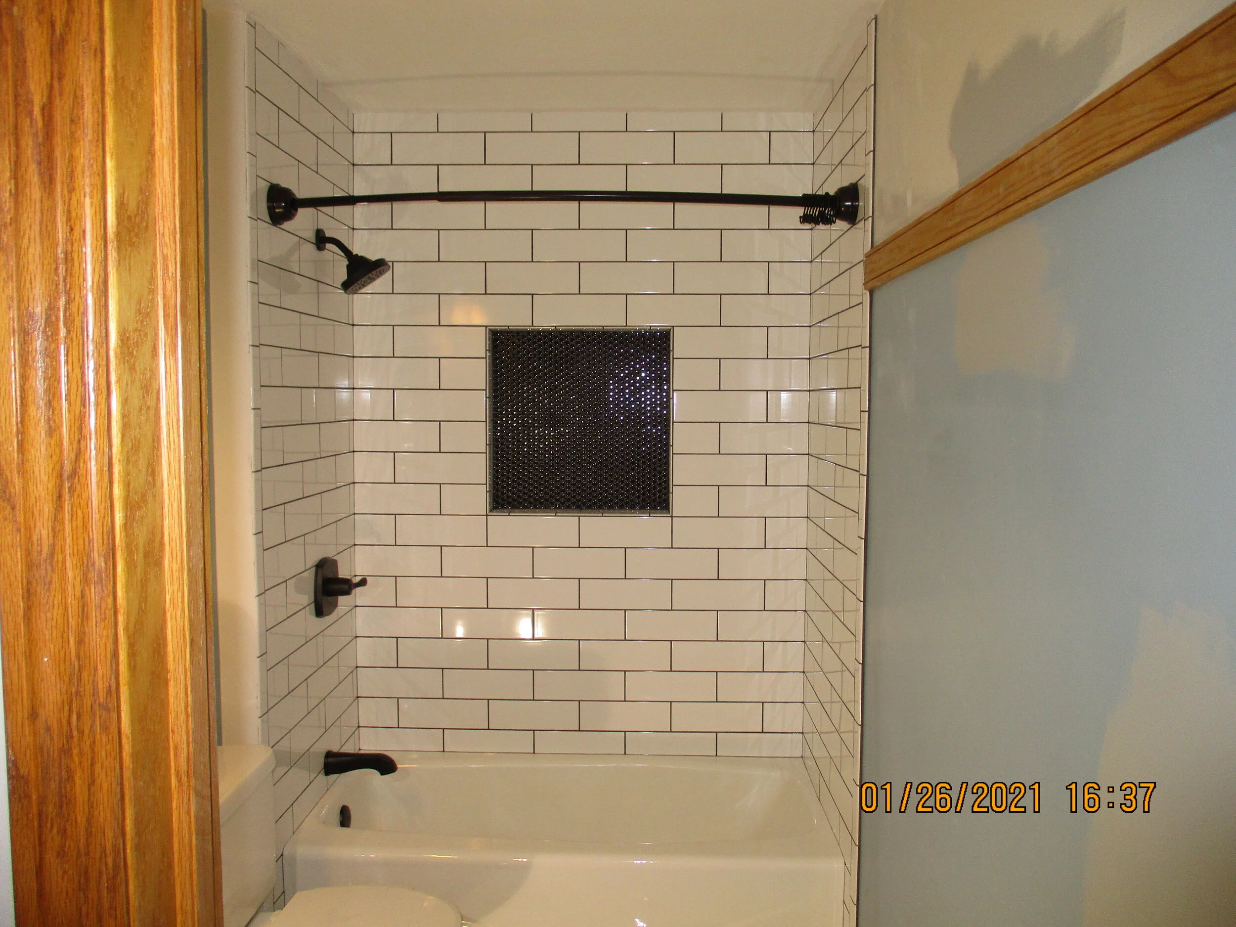 New tub with recessed niche and brick style wall tile
