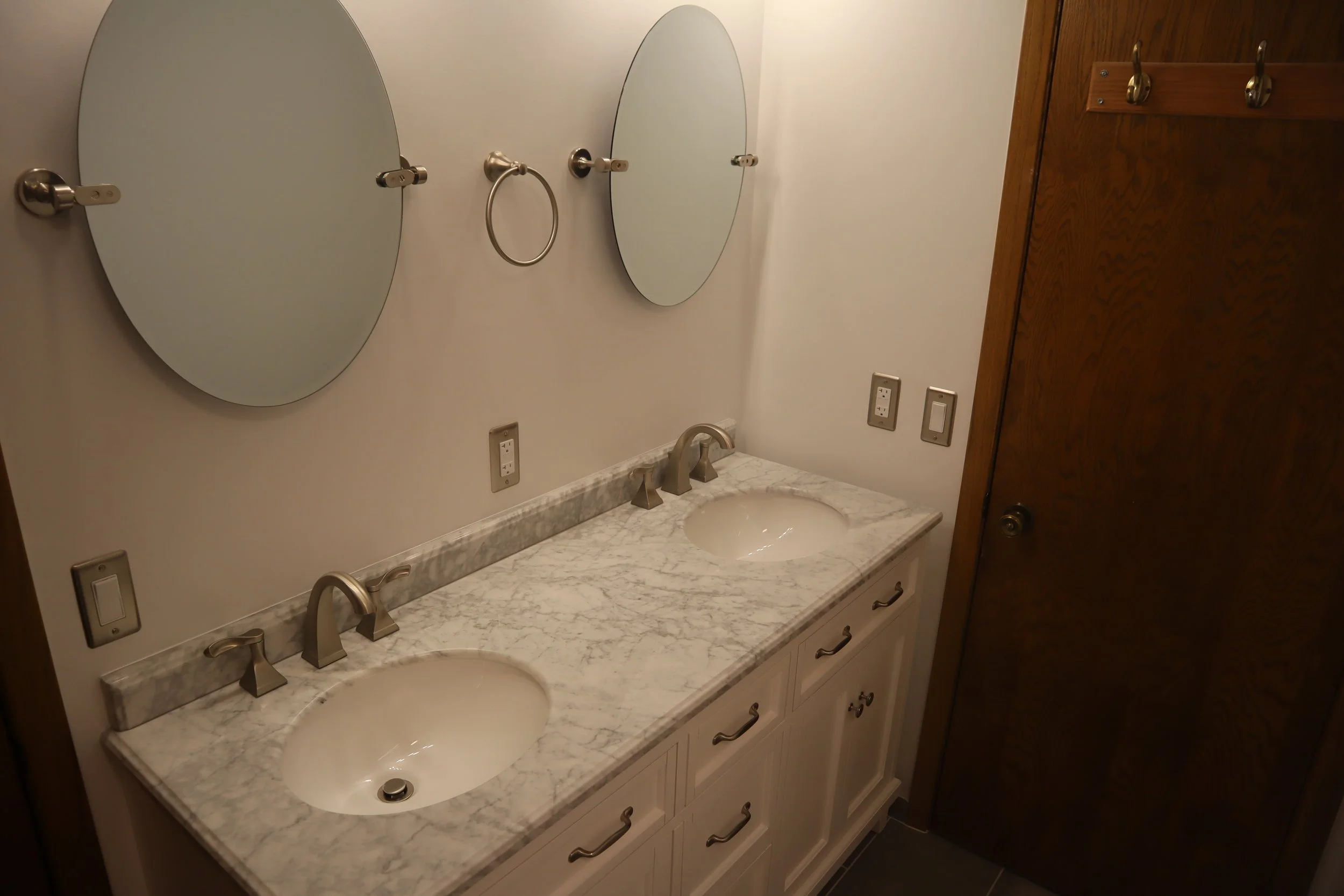 After: pivoting mirrors and updated lights, two bowl sink, marble countertop and new cabinet