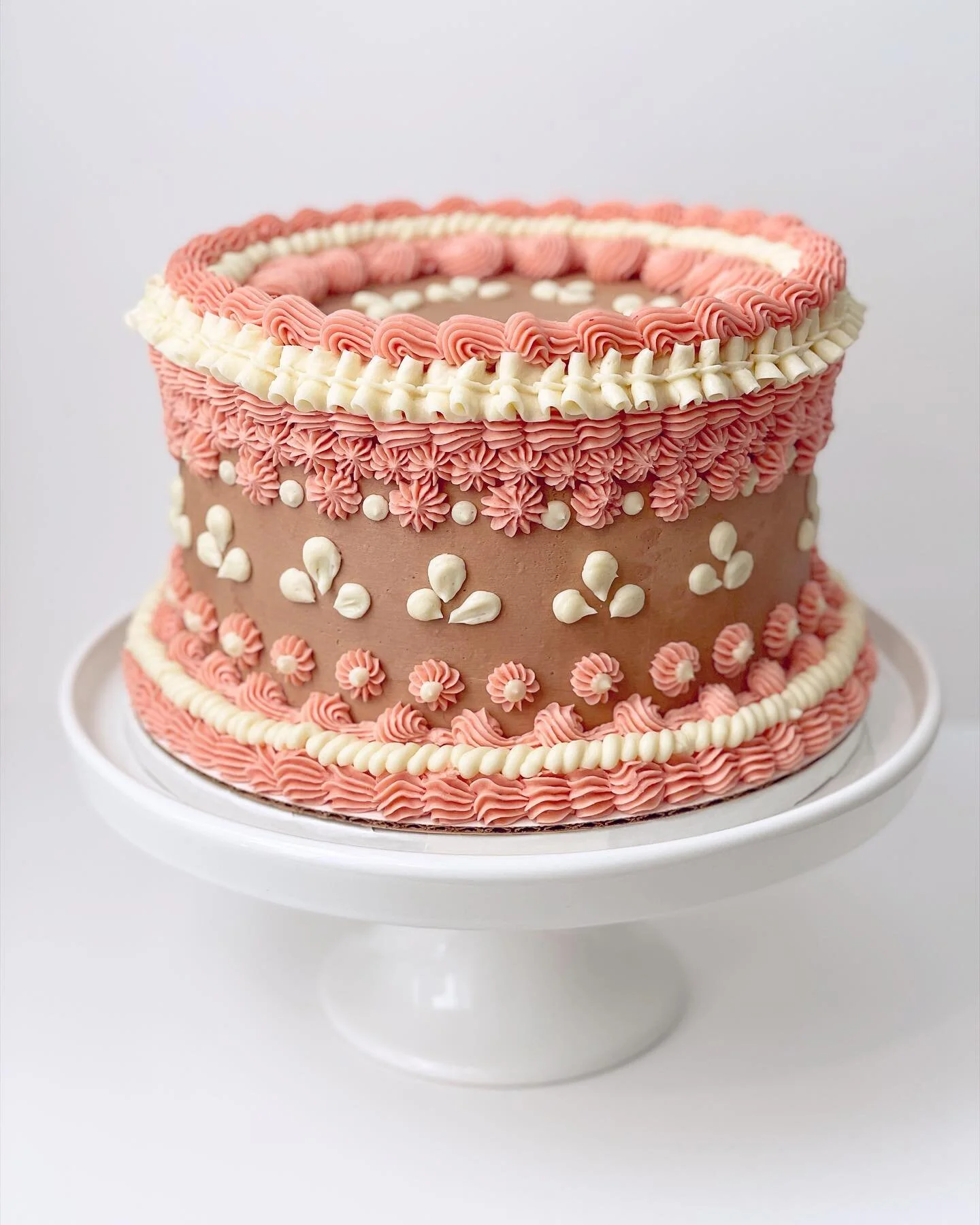 Okay, I might have gotten a tad carried away with the piping on this one, but who cares! This five layered black cocoa cake steals the show. 😍✨ Filled with alternating strawberries &amp; cream and chocolate cremeux, the absolute decadence in the ins