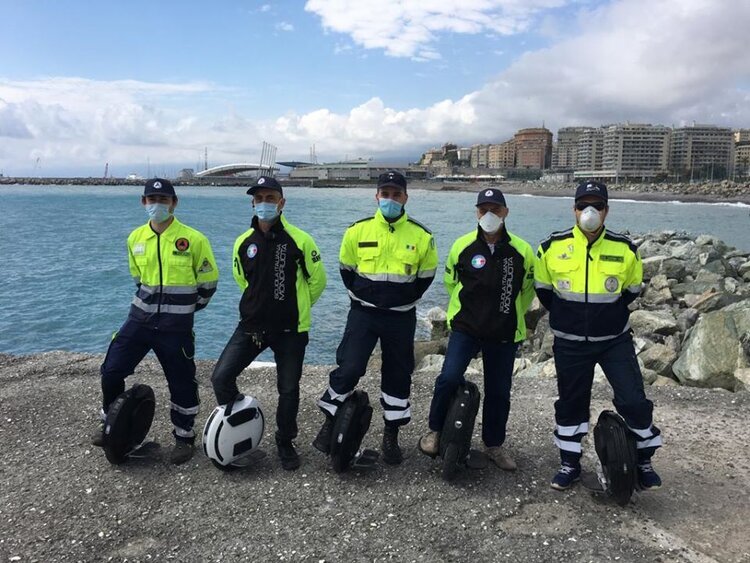 Five Members of the Genoa COVID Protection Team Standing with their Electric Unicycles by the Sea.
