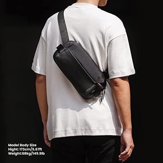 Person walking wearing a black tomtoc 8 inch Explorer sling bag on their back.jpg