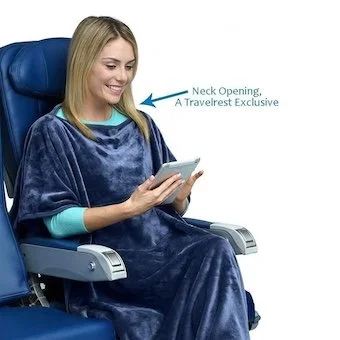 Woman using Travelrest poncho-style travel blanket showing neck opening design on plane seat