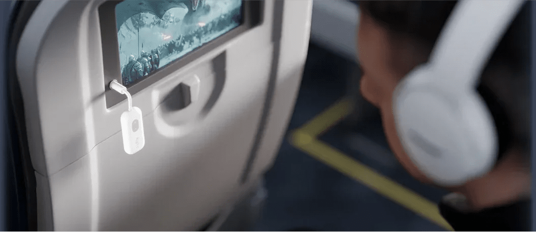 Passenger using Twelve south airfly bluetooth adapter on a plane with bluetooth headphones.