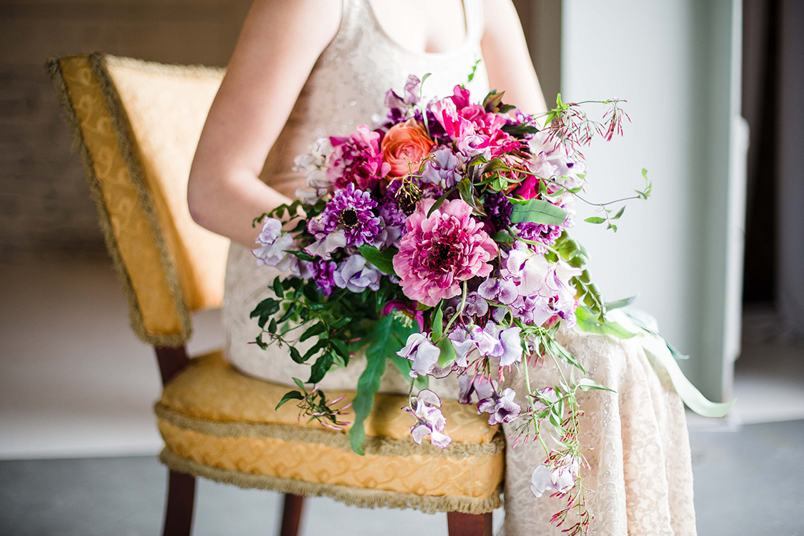  Cascading bridal bouquet with purple Japanese scabiosa, purple hellebores, Silvery Moon Japanese sweet pea, Charlotte ranunculus, peach ranunculus, jasmine vine and blue star fern, accented with vintage velvet and grosgrain cascading ribbons. Image 