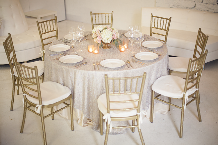 Low centerpiece in a gold compote with blush spray roses, apricot stock, Quicksand roses, white hydrangea and seeded eucalyptus, by Cincinnati wedding florist Floral Verde LLC. 