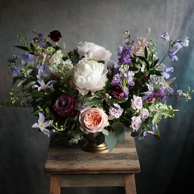 A centerpiece from Bailey and David's wedding with purple larkspur from @thatgirlsflowers.