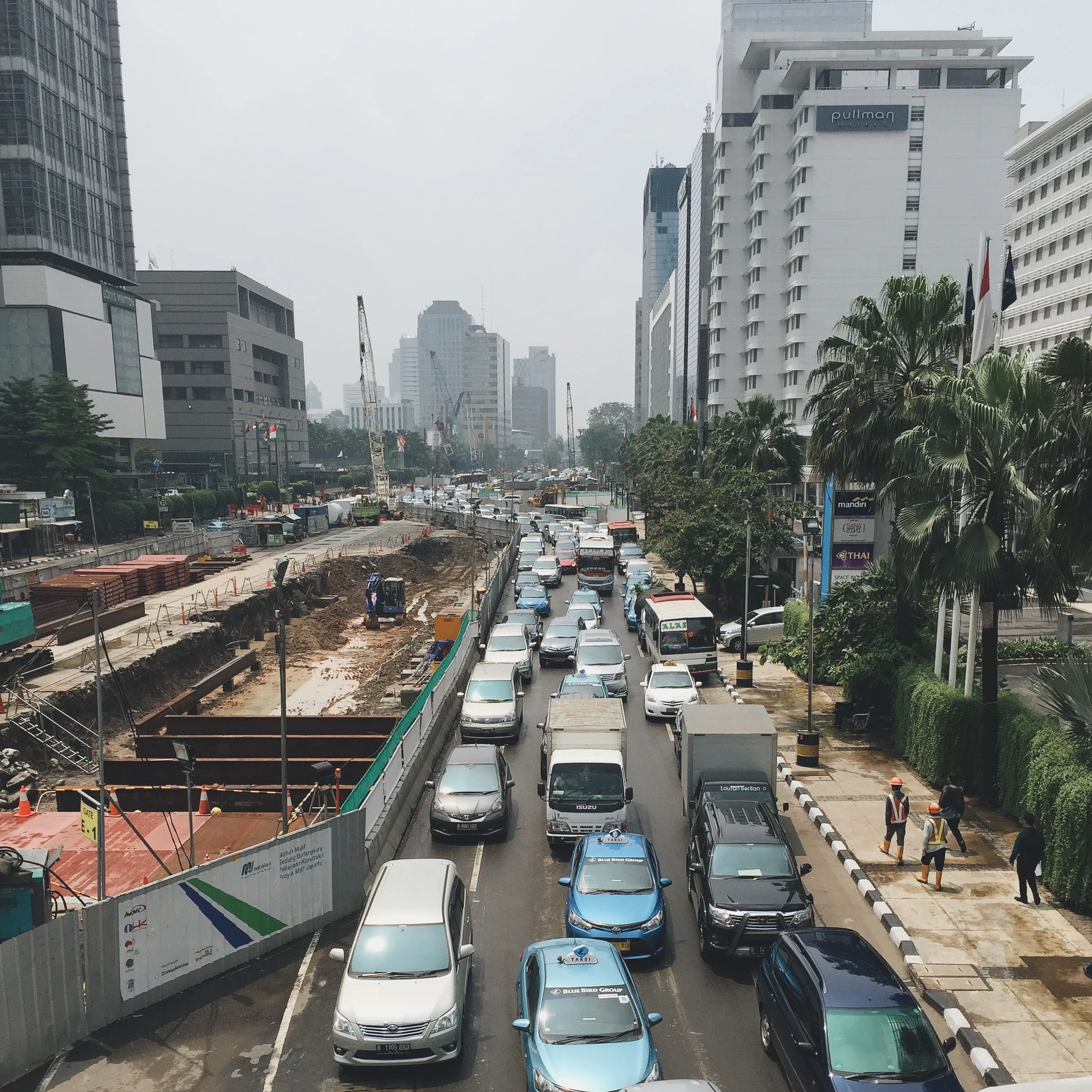 Traffic in Jakarta at a standstill next to a construction site for the new train system that will go above and below ground and will be the first mass-transit available in Jakarta, besides some busses and a regional train.