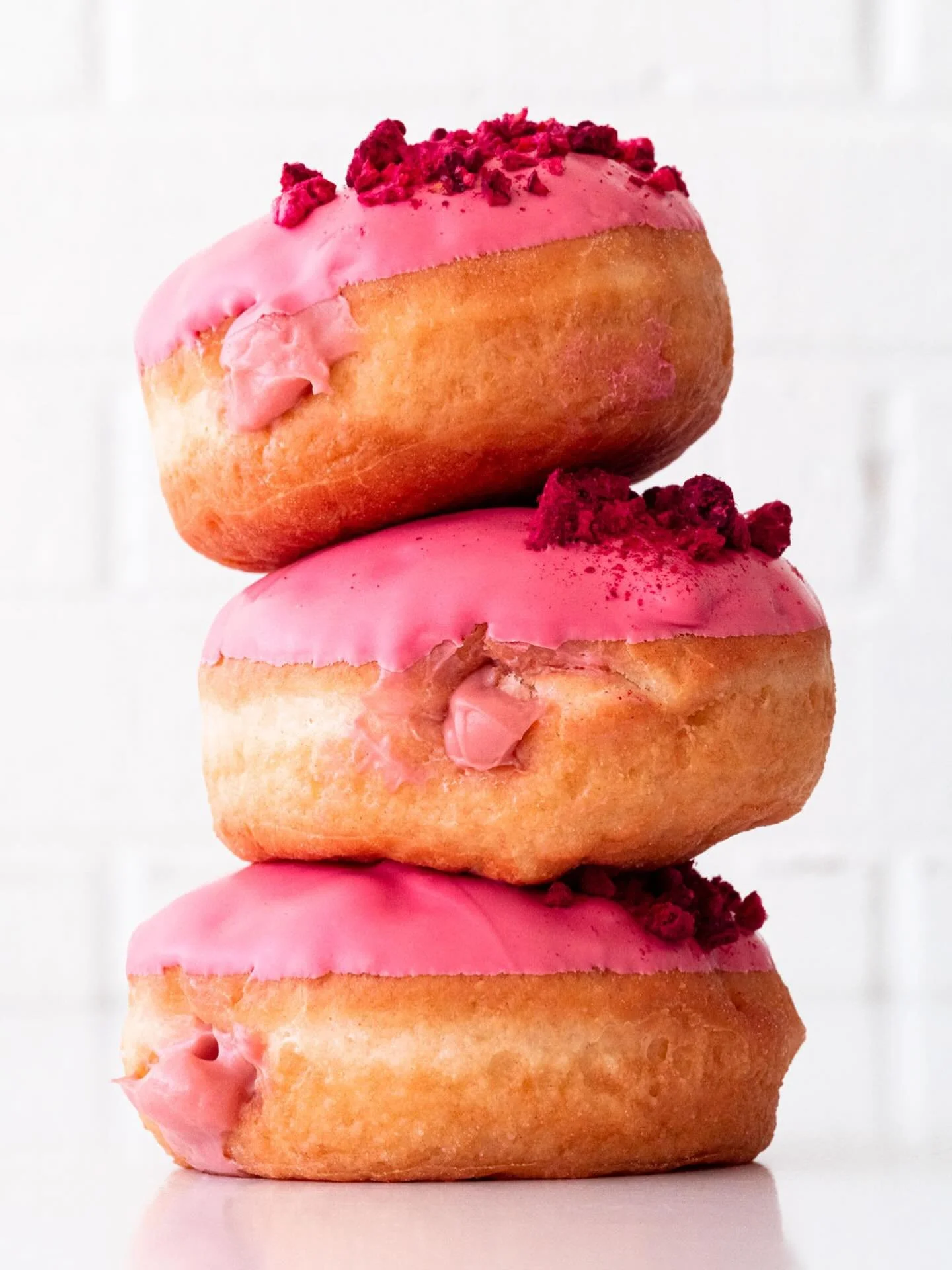 This is your reminder that Raspberry Cream is still around, but only for a limited time ❤️☁️🍩 Fluffy yeast doughnuts stuffed with raspberry pastry cream, dipped in pink candy, and sprinkled with freeze-dried raspberries. Get it here and @suarezbaker