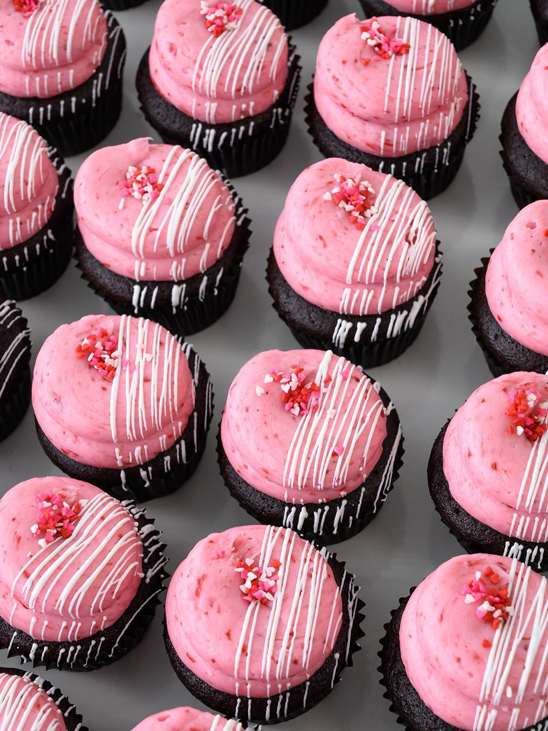 Valentine&rsquo;s Day may be over, but you never need an excuse for Chocolate-Covered Strawberry Cupcakes 🍫🍓🧁 Chocolate cupcake, strawberry preserves filling, strawberry buttercream icing, white chocolate, and heart sprinkles. Here and @suarezbake