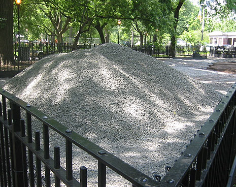 The pile of 1 1/4" clean rock that will form the drainage bed beneath the run. The rock is set below ground level between two layers of landscaping fabric to give water a place to drain after heavy rains and keep the surface a dry, healthy place.