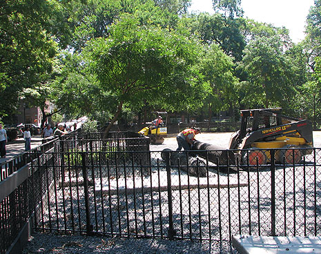 Lifting the roll of landscaping fabric. Two layers have been installed -- one beneath the drainage rock, and another between the rock and running surface 