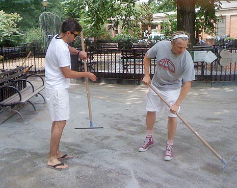 Volunteers move the benches and spread the screenings where the tractor can't reach