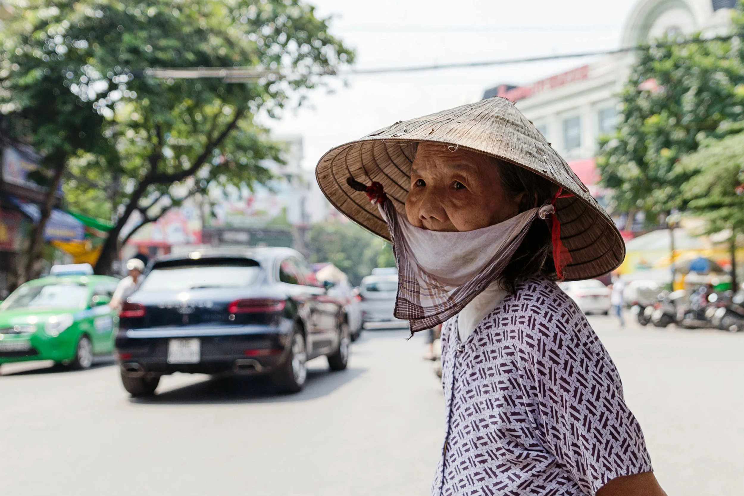 A woman waits to cross the busy street in Hanoi