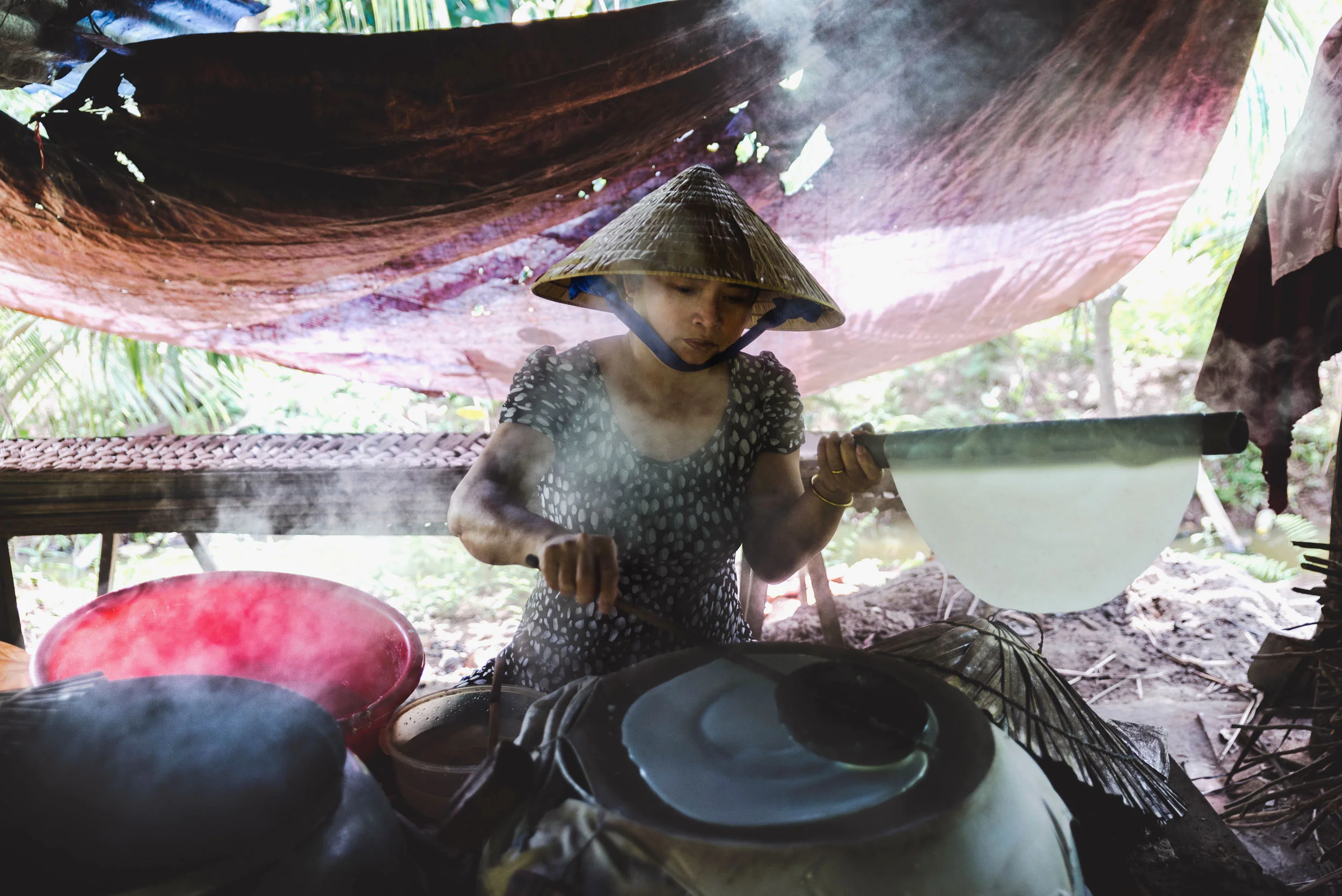 A woman making rice paper by hand.