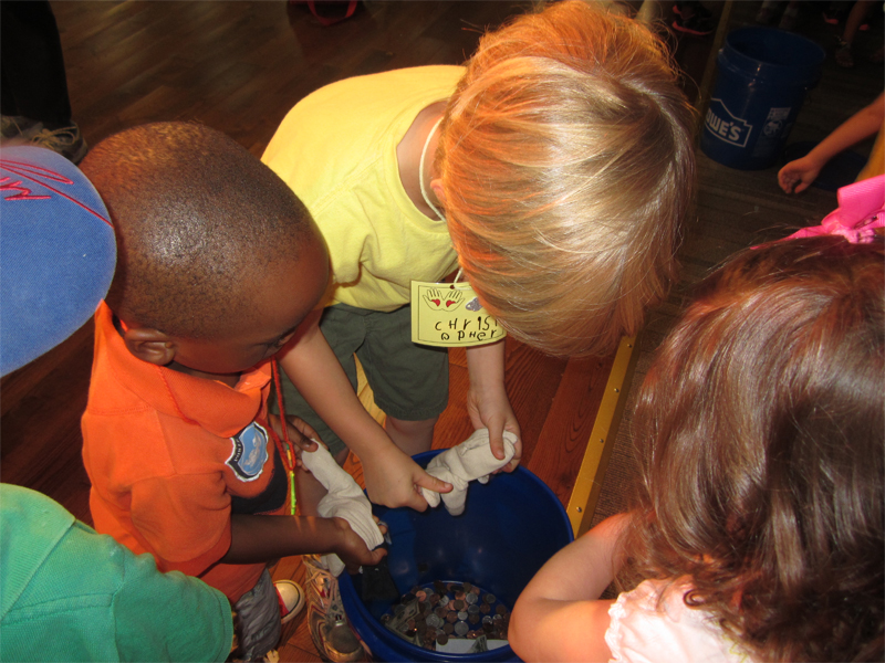 Children empty their offering gloves for Liberia