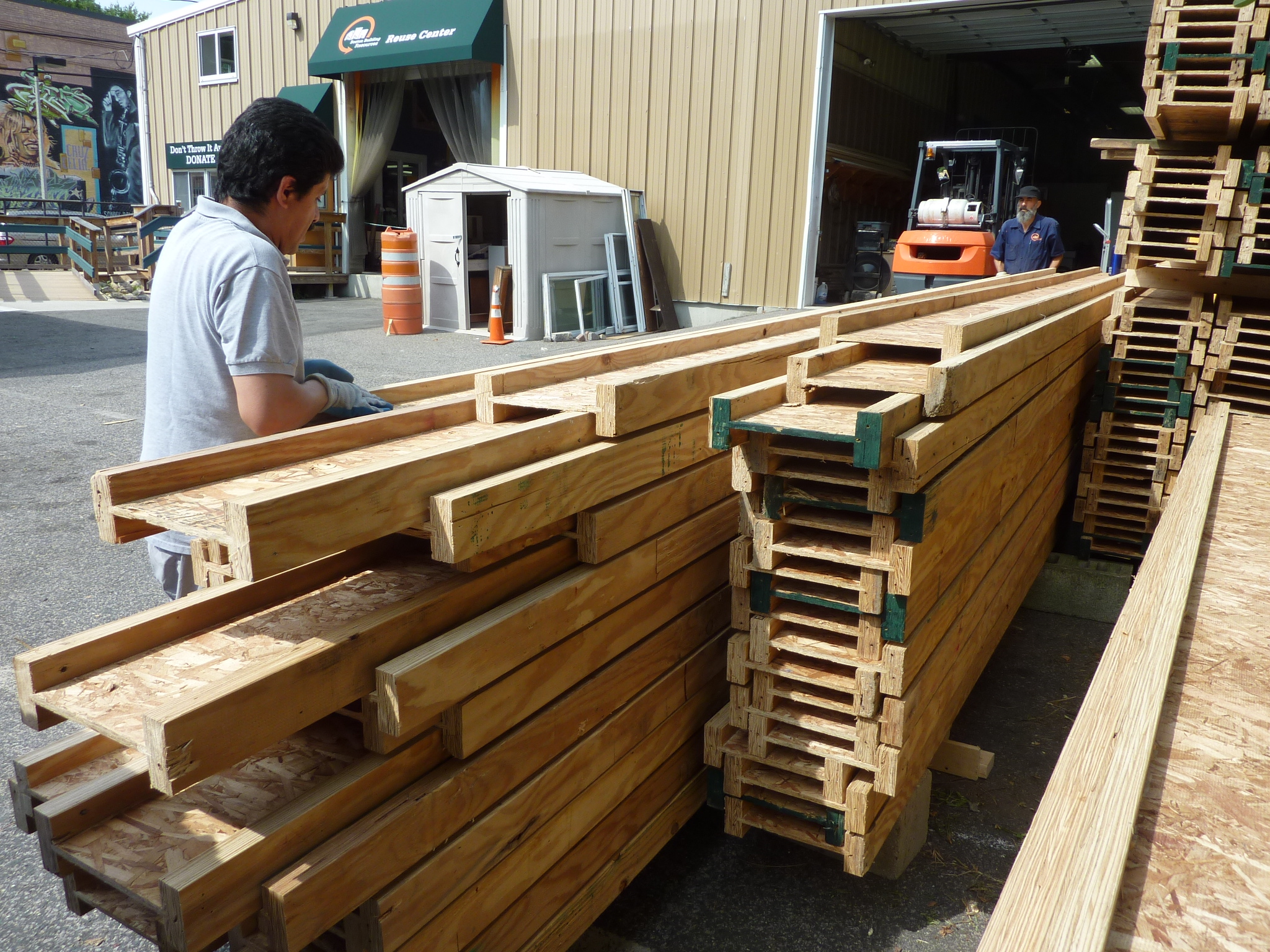 Donated I-beam trusses were unloaded by staffers Miguel Perez, left, and Paul Kiefer.