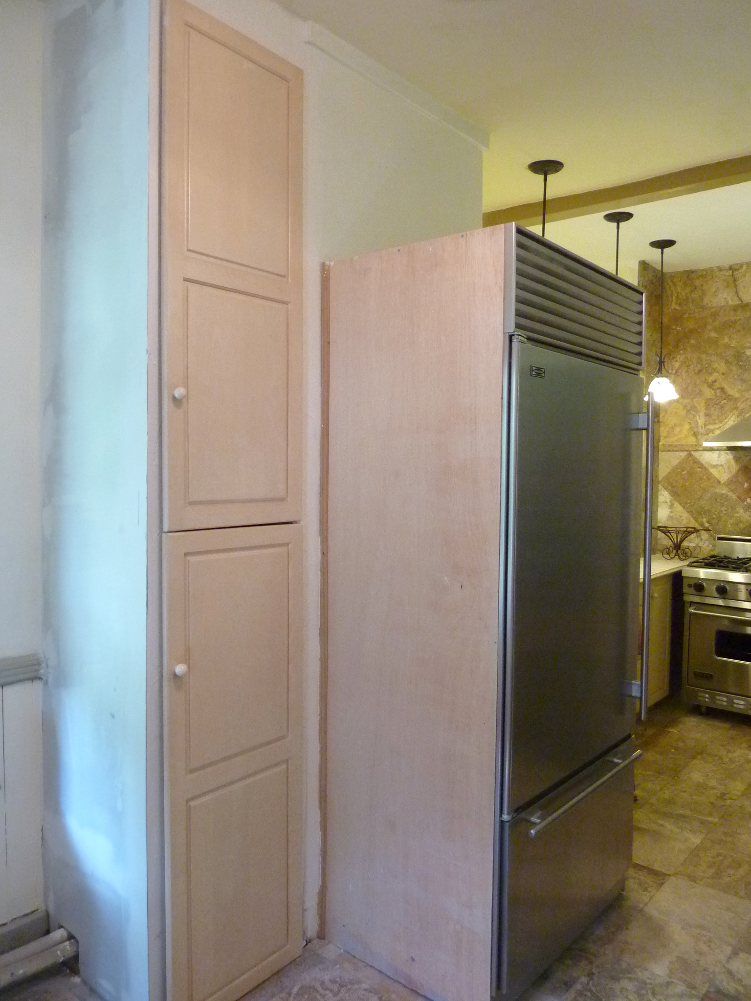 Cabinet doors were reconfigured to build a floor-to-ceiling cabinet.