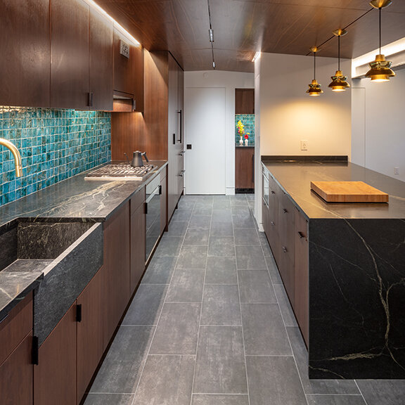 Walnut cabinets by Imperia topped with soapstone counters and soapstone farmer sink