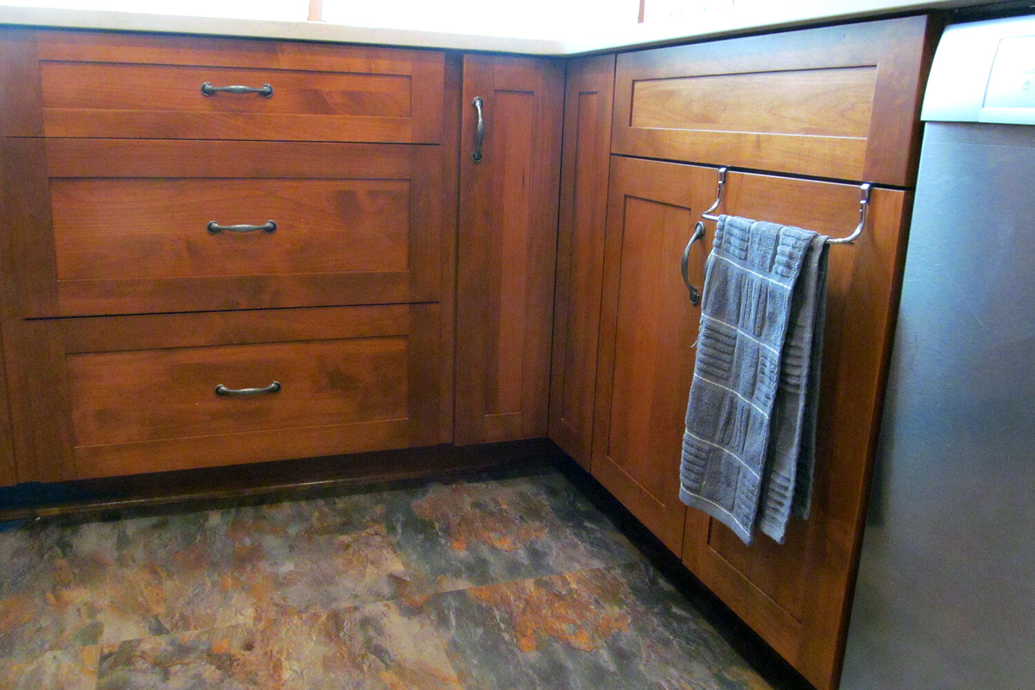 Place-n-Go flooring in ocean shale picks up the cabinets' natural wood tones.