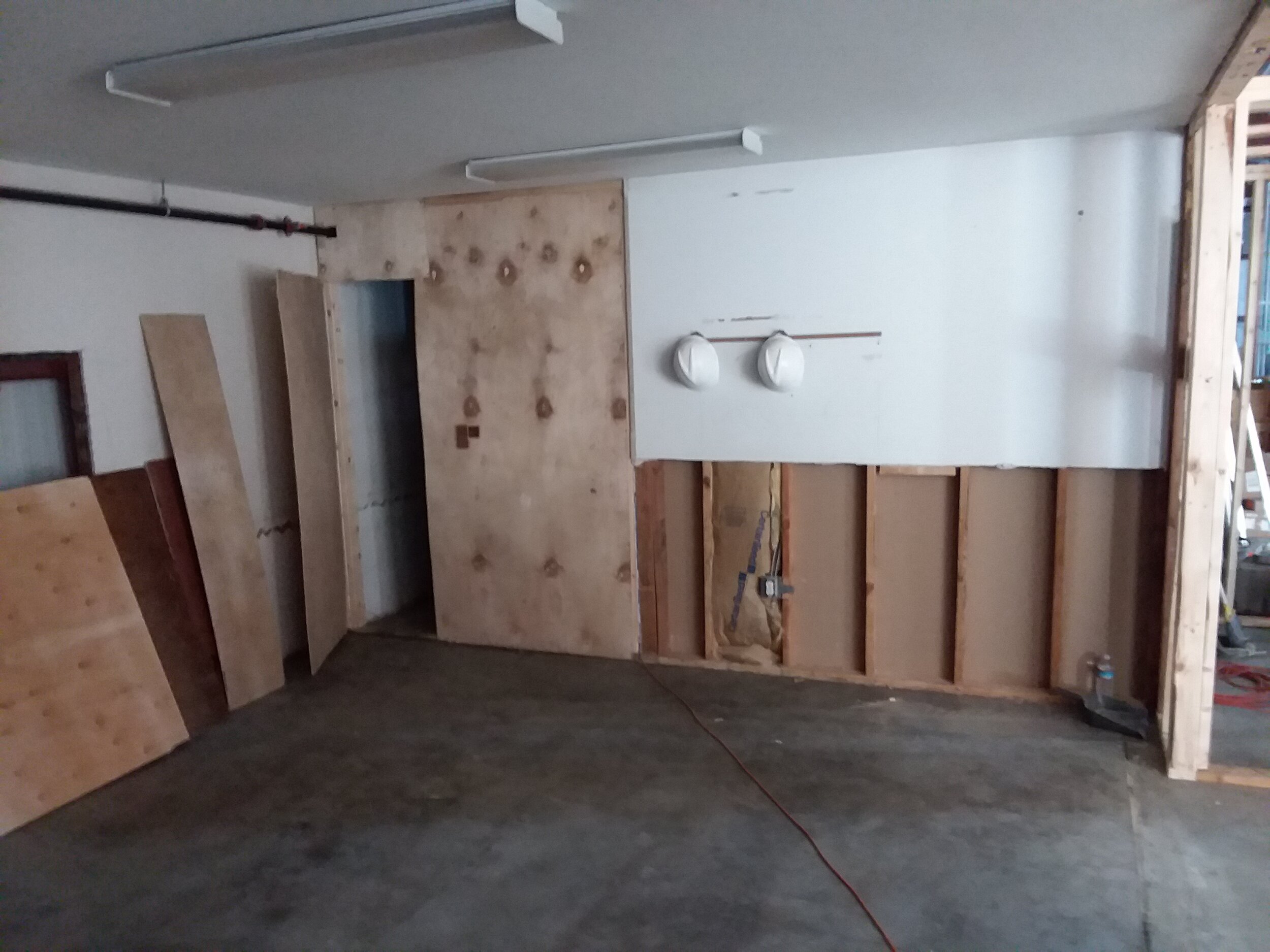 The entrance to a new accessible bathroom will be behind the plywood on the left.