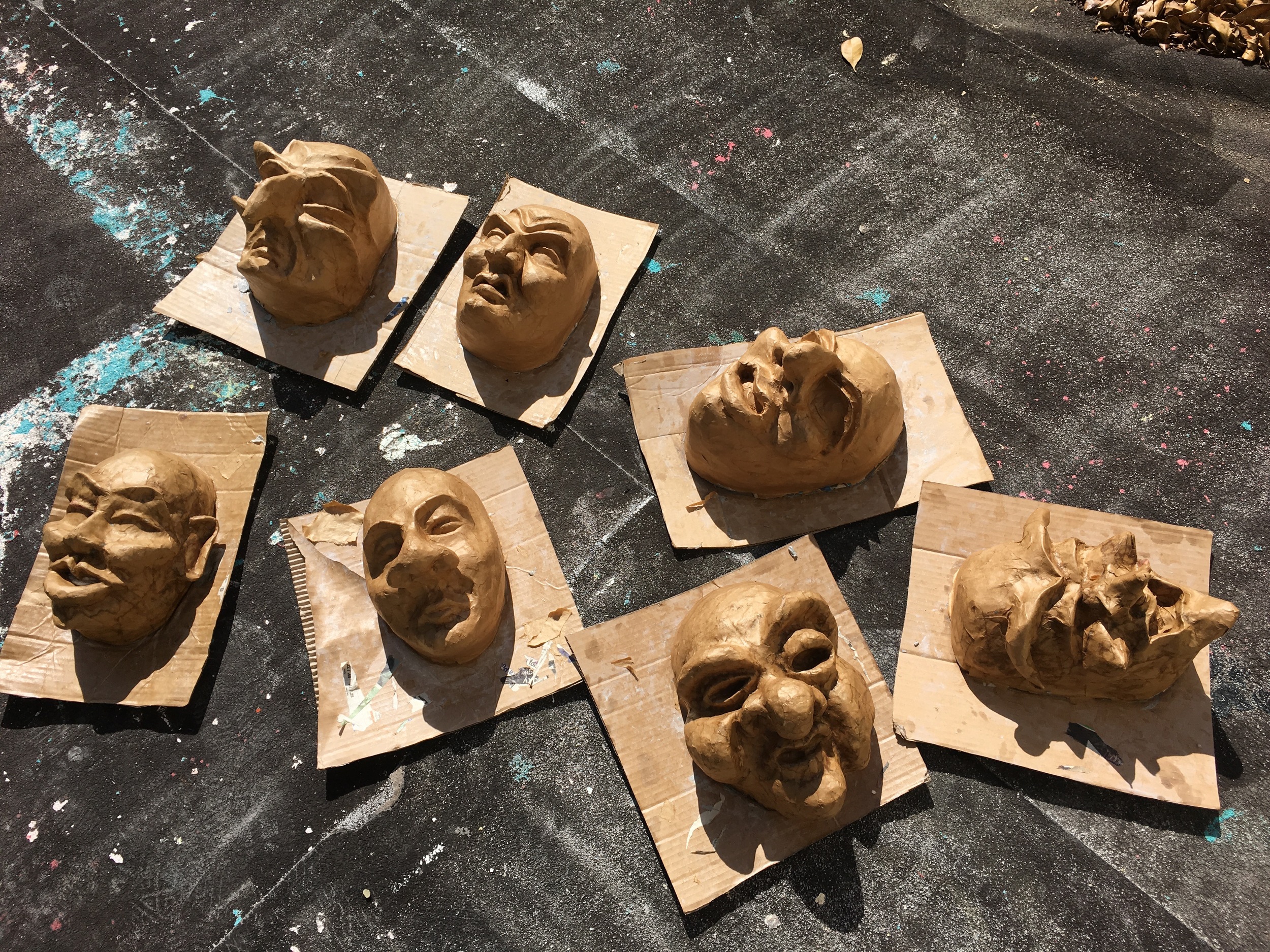 Group masks drying after papier mache