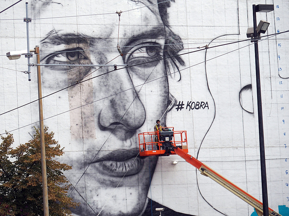  Early in the work on the mural, an image of the young Bob Dylan took shape on the side of the 15 Building at 5th and Hennepin in downtown Minneapolis on August 27, 2015. The artist's name -- Kobra -- appears as a hashtag. 