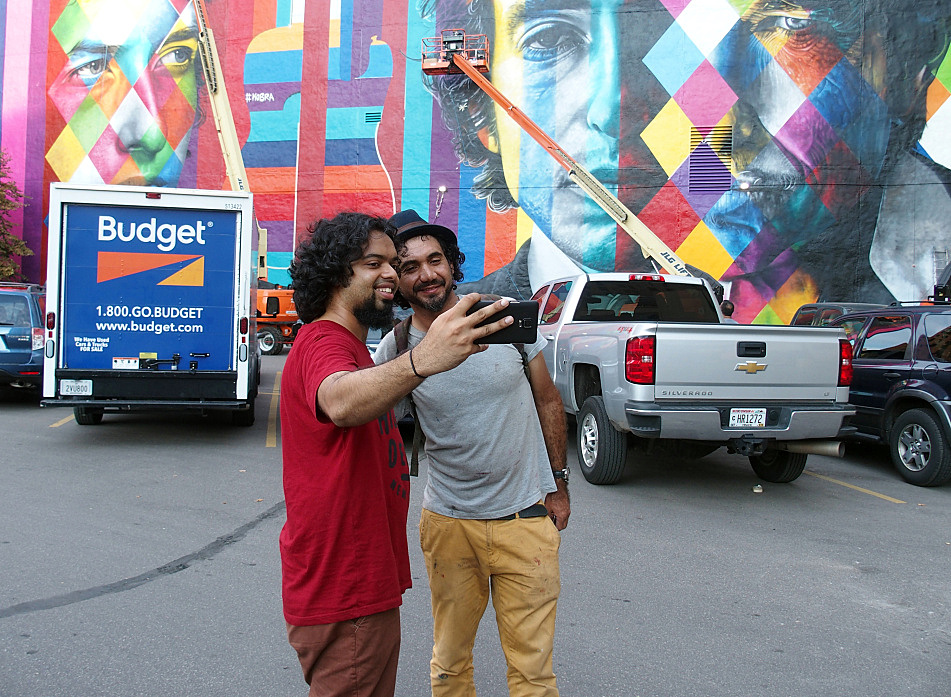 Despite a language barrier with most passersby, Eduardo Kobra was happy to pose with visitors for photographs when he took a break from painting, Sept. 5, 2015.