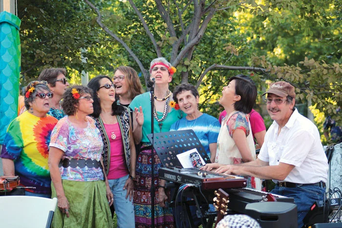 Several members of a choir wore flowers in their hair during a concert celebrating the 50th anniversary of the Summer of Love July 29 in Wolfe Park. (Sun Sailor staff photo by Seth Rowe)