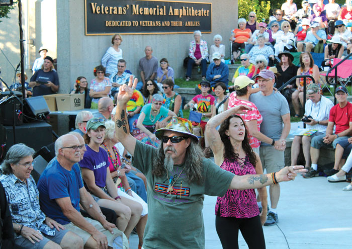 An attendee of the Summer of Love concert flashes peace signs after he joined other veterans recognized July 29 at Veterans’ Memorial Amphitheater in St. Louis Park. (Sun Sailor staff photo by Seth Rowe)