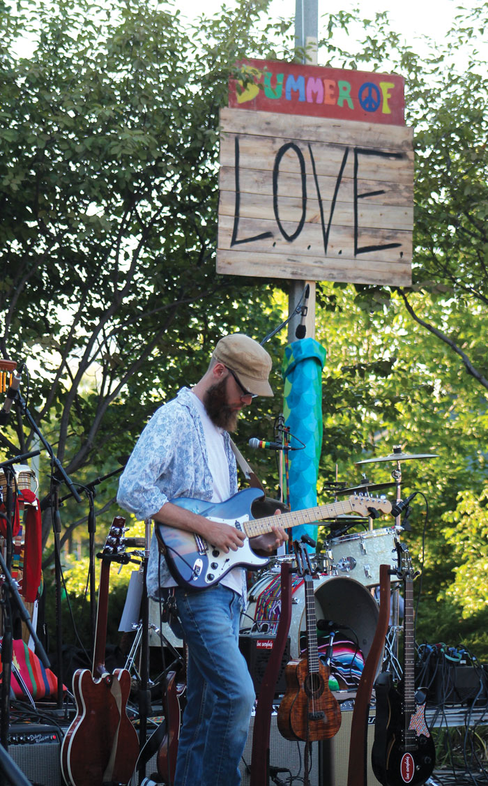  A banner proclaiming the Summer of Love adorned the Veterans’ Memorial Amphitheater Stage during the concert paying homage to the season’s 50th anniversary. (Sun Sailor staff photo by Seth Rowe) 