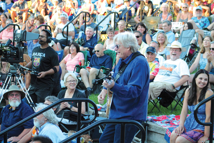  Kevin Odegard, who helped organize the Summer of Love concert July 29 in Wolfe Park, jams out in the crowd during a medley of classic tunes popular during the 1960s. (Sun Sailor staff photo by Seth Rowe) 
