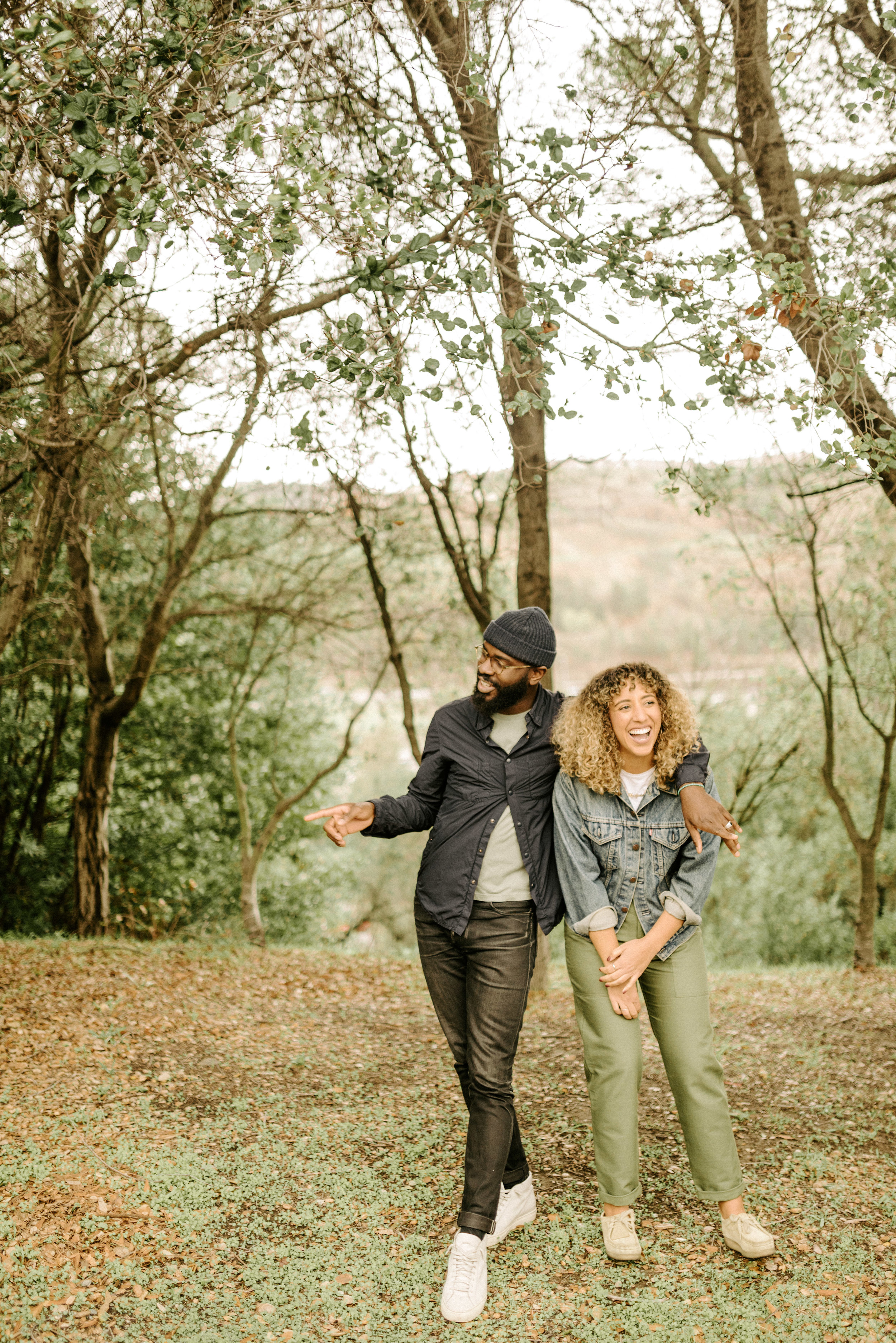 couple standing under the trees 