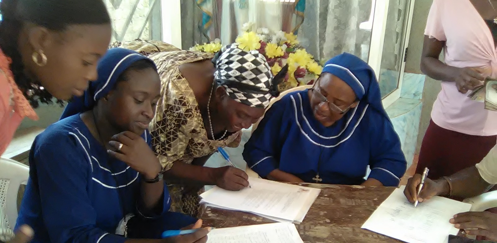 Sister Oresoa sits with members of the Sacred Heart Borrowing Group as they prepare to receive their loans