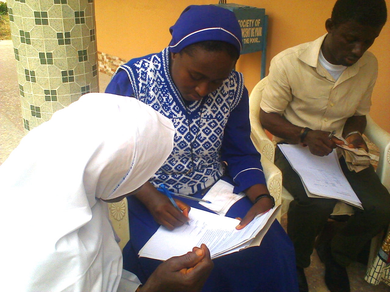 A young muslim woman receives her loan. While Anawim is a Catholic organization, they do not discriminate with regard to whom they offer assistance. 
