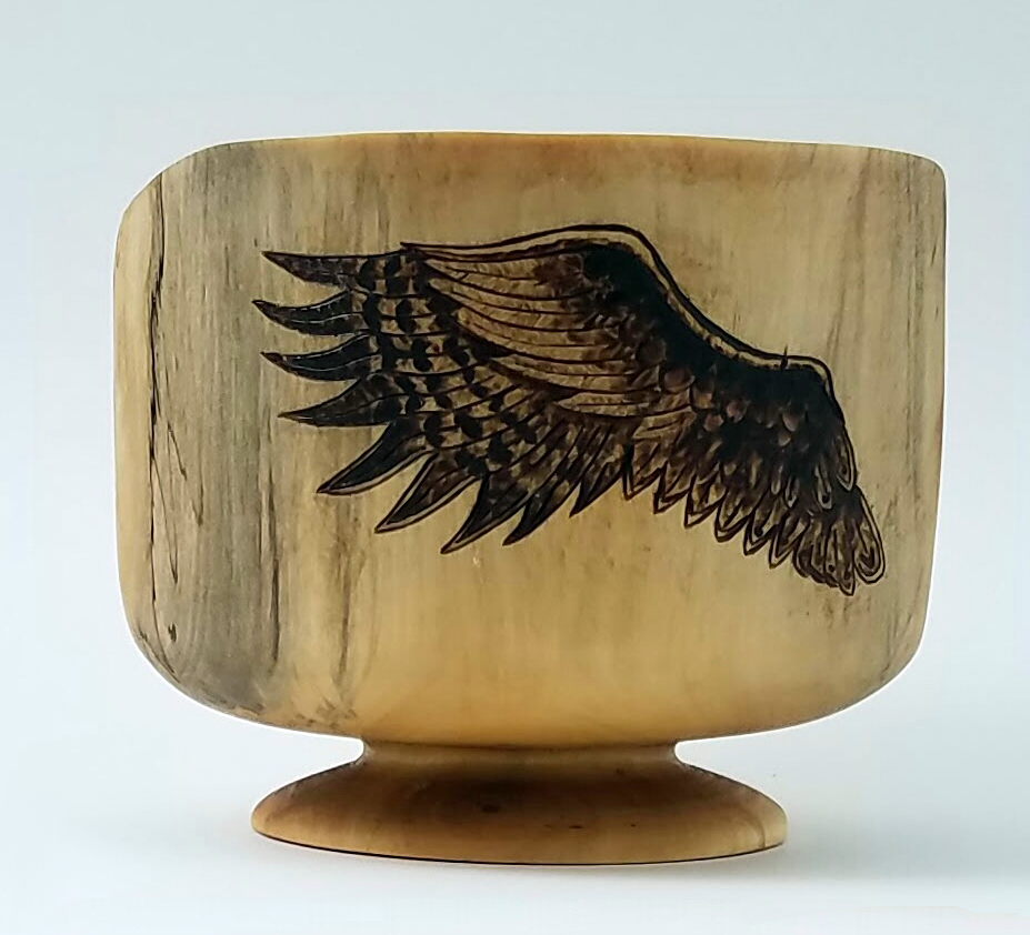 On the side of the bowl, Sarah wood burnt wings.