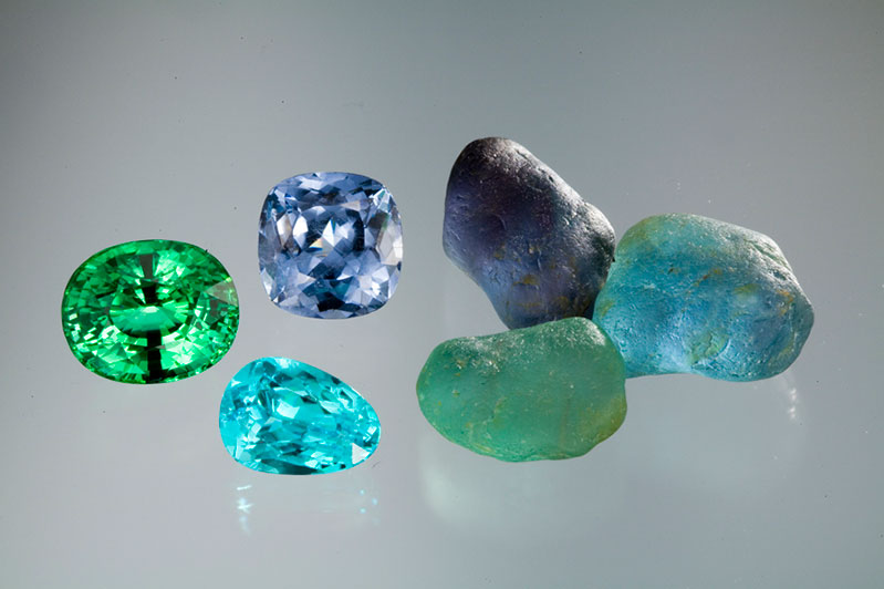  Gem quality nodules of copper-bearing tourmaline from Mozambique. Amongst the cut stones, the largest is 15+ carats. The 8-carat pear cut is the favored Paraiba color. 