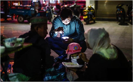 Past your bedtime? We've written a lot about Chinese dealers in Burma; but the image above is from a 14-photo slide show of Burma traders in China. In this image, a gem merchant from Burma feeds her child in the Delong jewelry night market in Ruili, in southwest China's Yunnan province. According to the slide show introduction, Ruili is one of the largest and oldest jade markets in China.