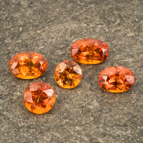 Hessonite garnets from Baja California, Mexico. The three ovals total 4.63 ct and are part of seven stones in Inventory #1551 . The round in the middle weighs 1.07 ct. The round at bottom left weighs 1.60 ct and is part of Bill Larson’s personal Baja California collection. (Photo: Mia Dixon)