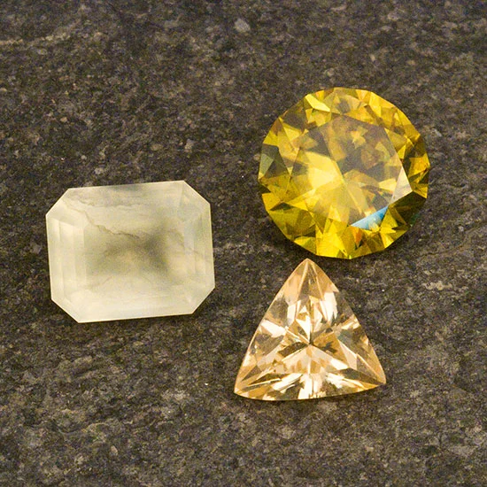 Un trío baja californiano. Clockwise from left, yellowish-green prehnite weighing 3.21 cts, sphene from Pino Solo weighing 3.61 cts and a trillion scheelite from the El Fenomeno Mine, Sierra Juares, Baja California, Mexico. (Photo: Mia Dixon; Collection: Bill Larson)