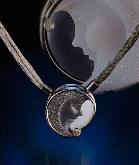 The Other Side of the Moon by Llyn L. Strelau, Calgary, Alberta, Canada. Pendant jewelry made of white and black engraved agate, diamonds, white gold and ruthenium blackened white gold. (Photo-collage: Lichtblick Foto-Design, Hiltrud und Jurgen Cullmann, Schwollen)