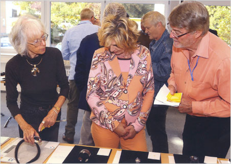 Color coordinated. Erika Van Pelt certainly takes first prize as best-dressed judge. Above left she wears a massive rutilated quartz star pendant, tastefully cut off-center, with rays beaming below. Below center she sports an oblong pentagon pendant featuring three multicolored tourmaline cut stones from Pala International's former Himalaya Mine. Click to enlarge.