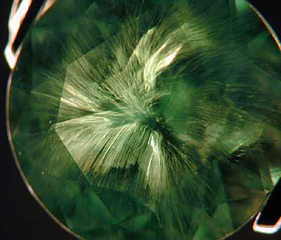 A classic example of a horsetail inclusion in a Russian demantoid garnet. (Photo: Wimon Manorotkul )