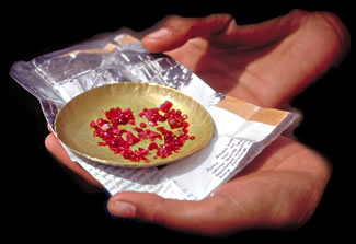 Background checks When you are examining a colored gemstone, act like a cop – always do a background check. The color of the background against which a gem is examined can have a major effect on color. Which is why wily Burmese and Thai miners traditionally offer up rubies to buyers on brass plates or yellow table tops. The yellow background color countesent in ruby, making the gems appear more red. Yellow cellophane-lined stone papers or brass tweezers serve the same purpose. Don’t be a sucker. For judging color, a plain white background. Above, rubies and red spinels are typically traded on brass plates in Mogok, Burma. Photo © R.W. Hughes