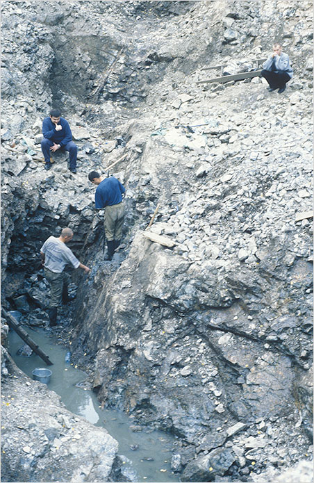 The thinkers. Mining demantoid is back-breaking work—at least for some. These miners are working the Kladovka Mine in the mid 2004. (Photo: Bill Larson)