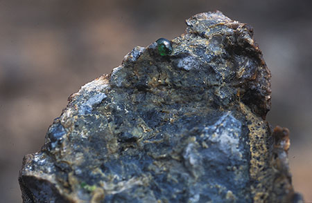 Peek-a-boo. A green demantoid emerges from its matrix. From the Kladovka Mine, 2004. (Photo: Bill Larson)