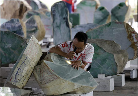 A merchant inspects a jade boulder at the emporium, June 24, 2015. See a brief streaming video about Hpakant jade mining produced by Democratic Voice of Burma. DVB produced a video in the same series that profiles the artisan workshops of Mandalay.