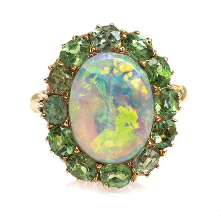 Lot 33 from the Bass Coors collection is a gray opal (12.28 x 9.35 mm) surrounded by twelve oval mixed-cut demantoid garnets of varying hues. (Photo courtesy Leslie Hindman Auctioneers)